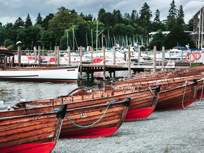 Visual of a row of paddle boats on the gravel at Lake Windermere in the Lake District.